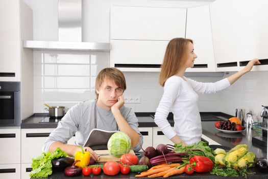 Man unhappy with cooking sitting in kitchen