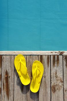 Yellow sandals by a swimming pool 