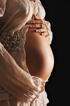 Pregnant woman belly over black