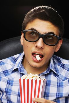 Young man watching movie in 3D glasses at cinema