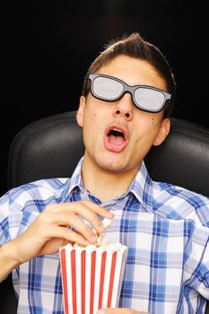 Young man watching movie in 3D glasses at cinema