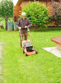 Senior man mowing the lawn