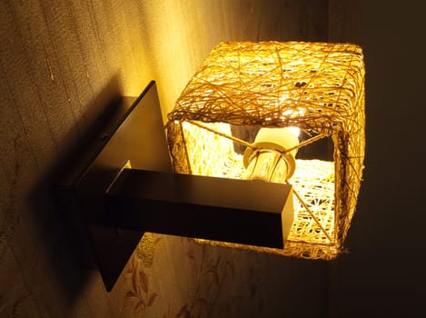 Wall lamp with warm light in room interior turned on