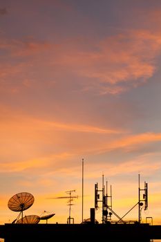 Worldwide Communication,  Satellite and other antenna network against beautiful sky at sunset