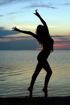 Silhouette of a sexy young woman standing in water