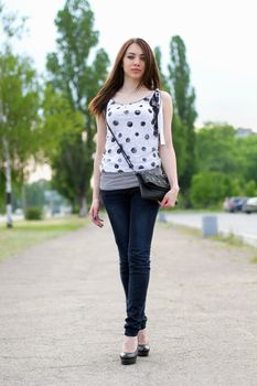 Sexy young woman walking on the sidewalk