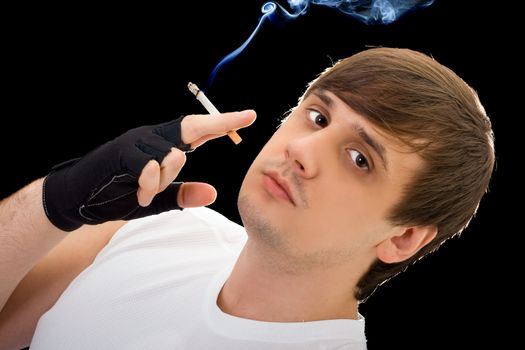 Young  man with a cigarette. Isolated on black