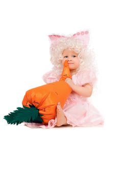 Baby girl plays with a carrot. Isolated on white