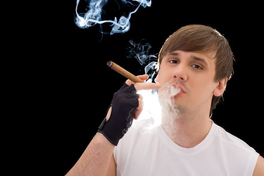 Young man smoking a cigar. Isolated on black
