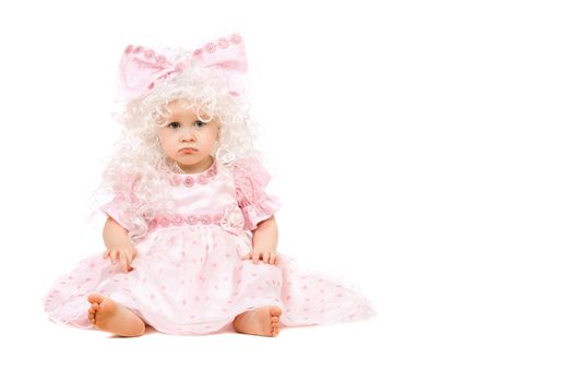 Sad baby girl in a pink dress. Isolated