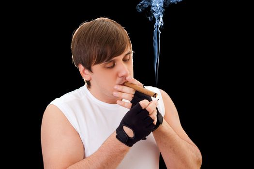 Young man sets fire to a cigar