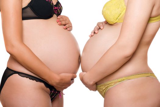 Two bellies of pregnant young women. Isolated on white