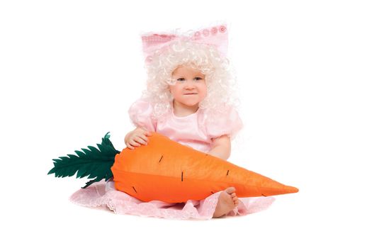 Funny baby girl plays with a carrot. Isolated