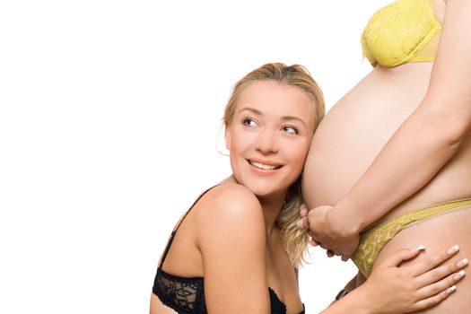 Happy young woman and belly of pregnant girlfriend. Isolated