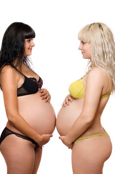 Pregnant blonde and brunette. Isolated on white