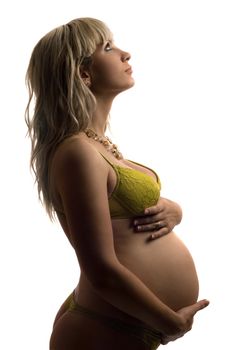 Pregnant young woman in yellow lingerie. Isolated on white