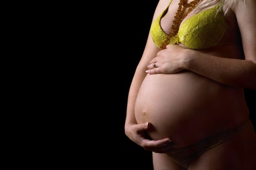 Belly of a pregnant girl. Isolated on black
