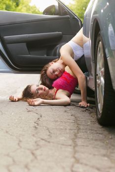 Two beautiful young women lying on the road