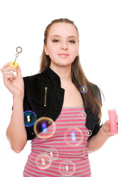 Portrait of smiling young woman blow bubbles. Isolated