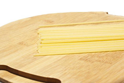 spaghetti pasta on wooden board isolated on white