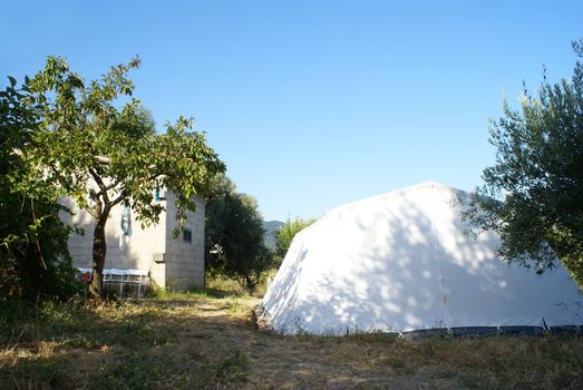 large camping tent in the countryside over blue sky