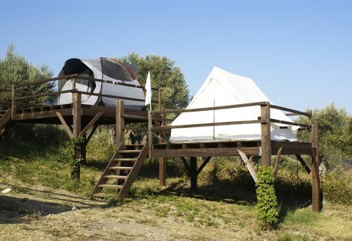 tents on stilts over the blue sky and countryside. Camping