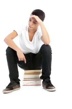 Teenage boy sitting on top of a pile of books waiting and watching with his hand raised to his forehead isolated on white
