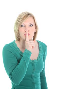 Excited woman giving a shushing gesture with her finger raised to her lips as she requests silence and secrecy for a surprise isolated on white Excited woman giving a shushing gesture with her finger raised to her lips as she requests silance and secrecy for a surprise isolated on white