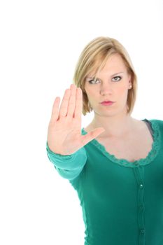 Determined young woman calling a halt by raising her hand palm forwards in a gesture to stop or halt isolated on a white background Determined young woman calling a halt by raising her hand palm forwards in a gesture to stop or halt