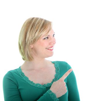 Smiling young blonde woman looking sideways pointing with her finger towards blank copyspace on the right of the frame isolated on white Smiling young blonde woman standing sideways pointing with her finger towards blank copyspace on the right of the frame isolated on white