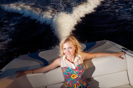 young blonde girl sitting on the yacht
