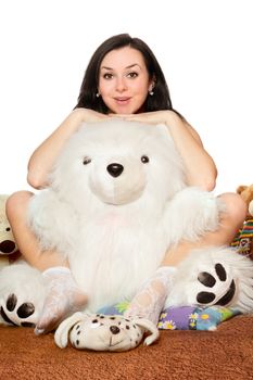 Pretty girl sitting in an embrace with a large teddy bear