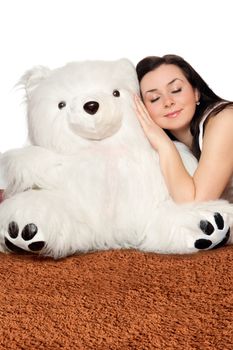 Girl asleep leaning against a big teddy bear