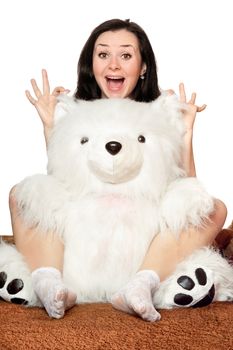 Cheerful girl plays with a big teddy bear