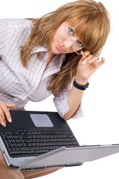 The young woman in glasses sits with the laptop. Isolated