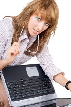 The young woman in glasses sits with the laptop. Isolated on white