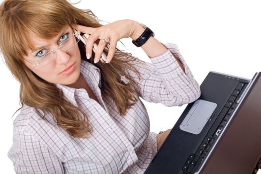 The young woman in glasses sits with the laptop and phone. Isolated