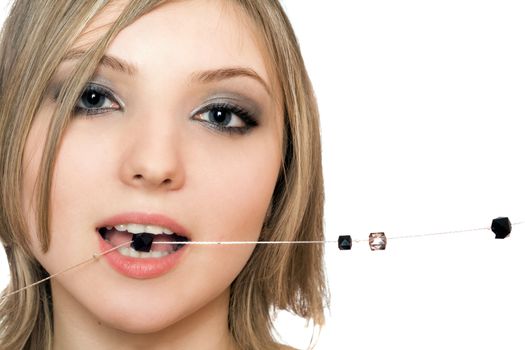 Close-up portrait of pretty young woman with a bead in her mouth