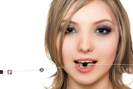 Close-up portrait of beautiful young woman with a bead in her mouth
