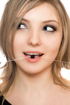 Close-up portrait of attractive young woman with a bead in her mouth