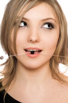Close-up portrait of attractive girl with a bead in her mouth