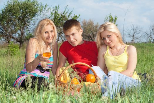 Two attractive blonde and young man outdoors