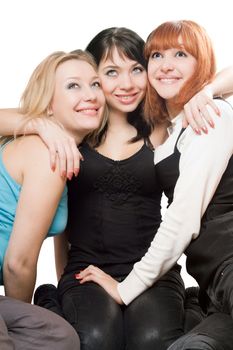 Three beautiful young women sitting and smiling. Isolated