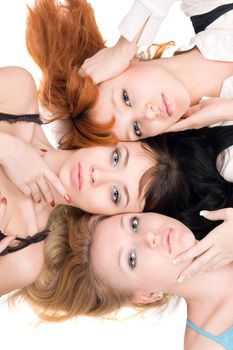 Portrait of three beautiful women lying on white background