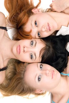 Close-up of three thoughtful women lying on white background