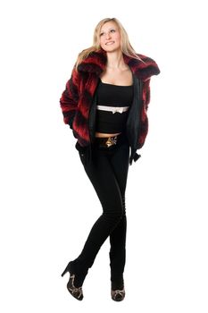 Happy young blond woman in a fur jacket. Isolated on white