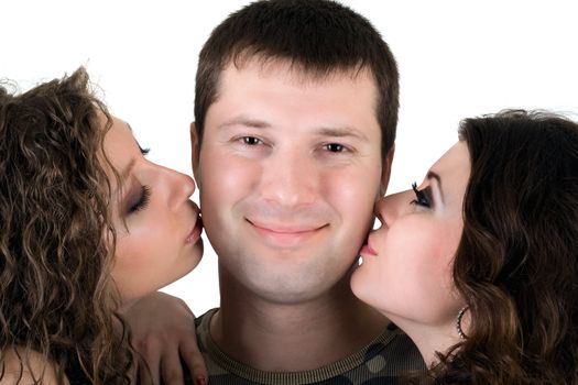 Two beautiful girls kiss the young man