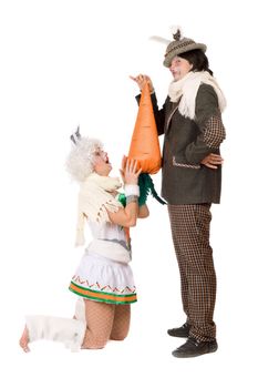 Funny young couple with carrot dressed as rabbits. Isolated on white