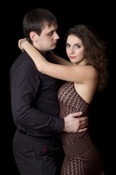 Portrait of young nice hugging couple. Isolated on black