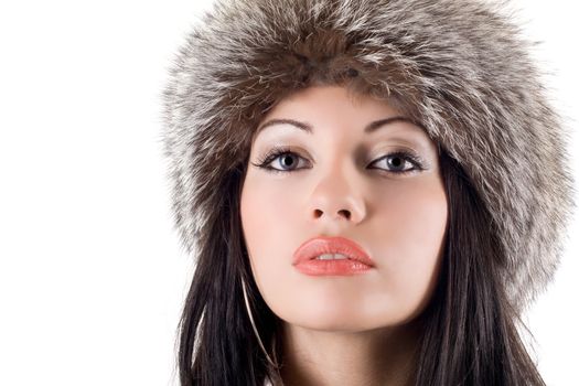 Portrait of the young woman in a fur cap